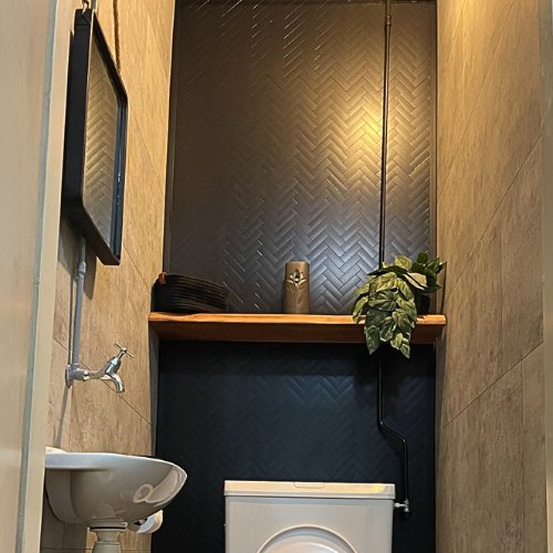 Kundenfoto: dunkles Gäste-WC mit Fischgrät Klebefliesen schwarz matt