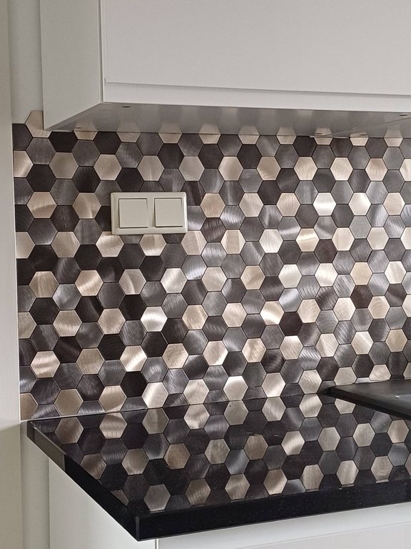 Alte Fliesen überkleben: selbstklebende Mosaikfliesen in Multi-Metalloptik an der Küchenwand mit Steckdose