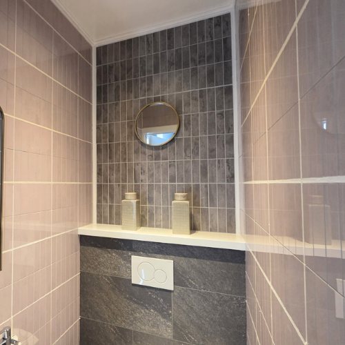 WC-Rückwand mit dunkelgrauen Klebefliesen im italienischen Stil